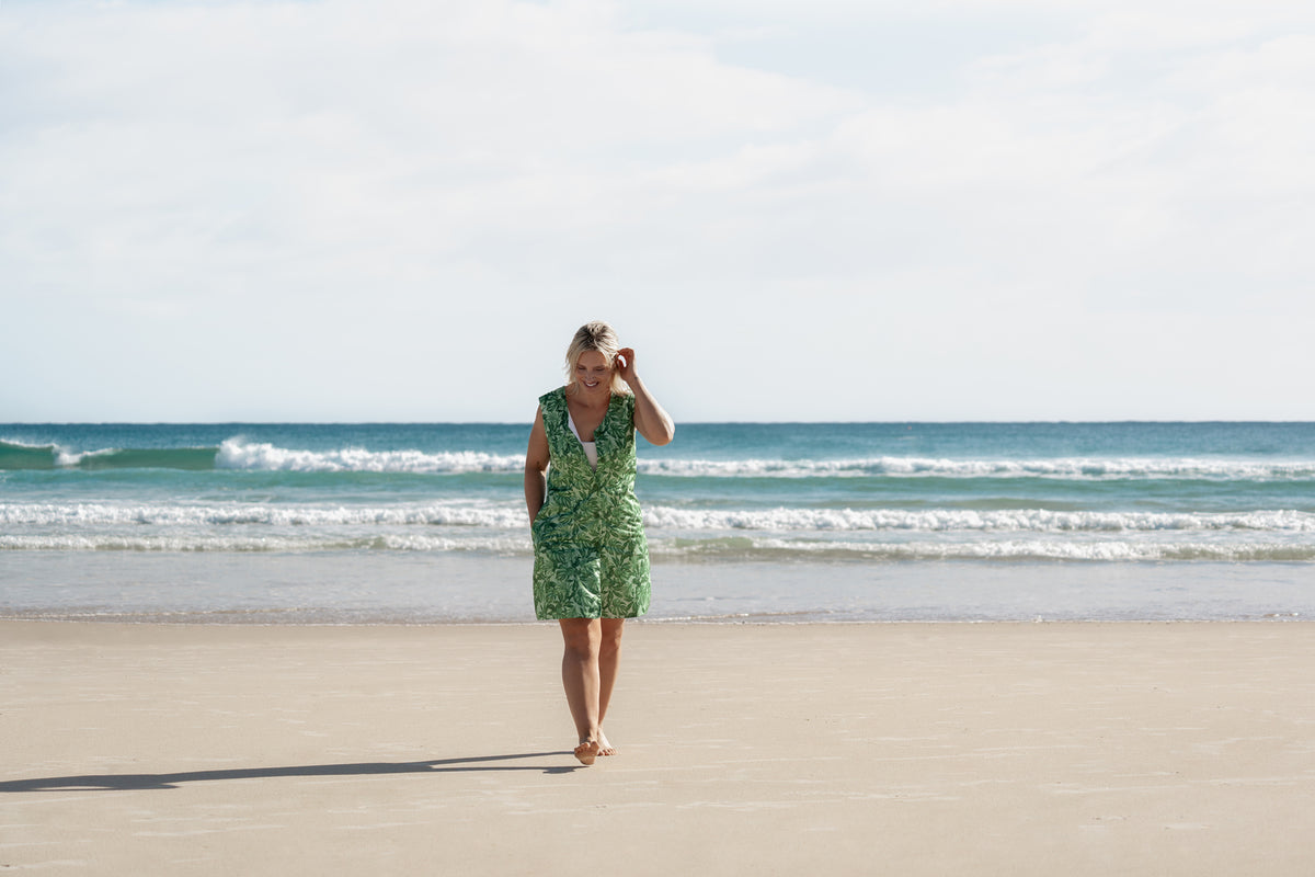 Woman on the sand wearing the Neren Signature After-Swim Dress in Canopy