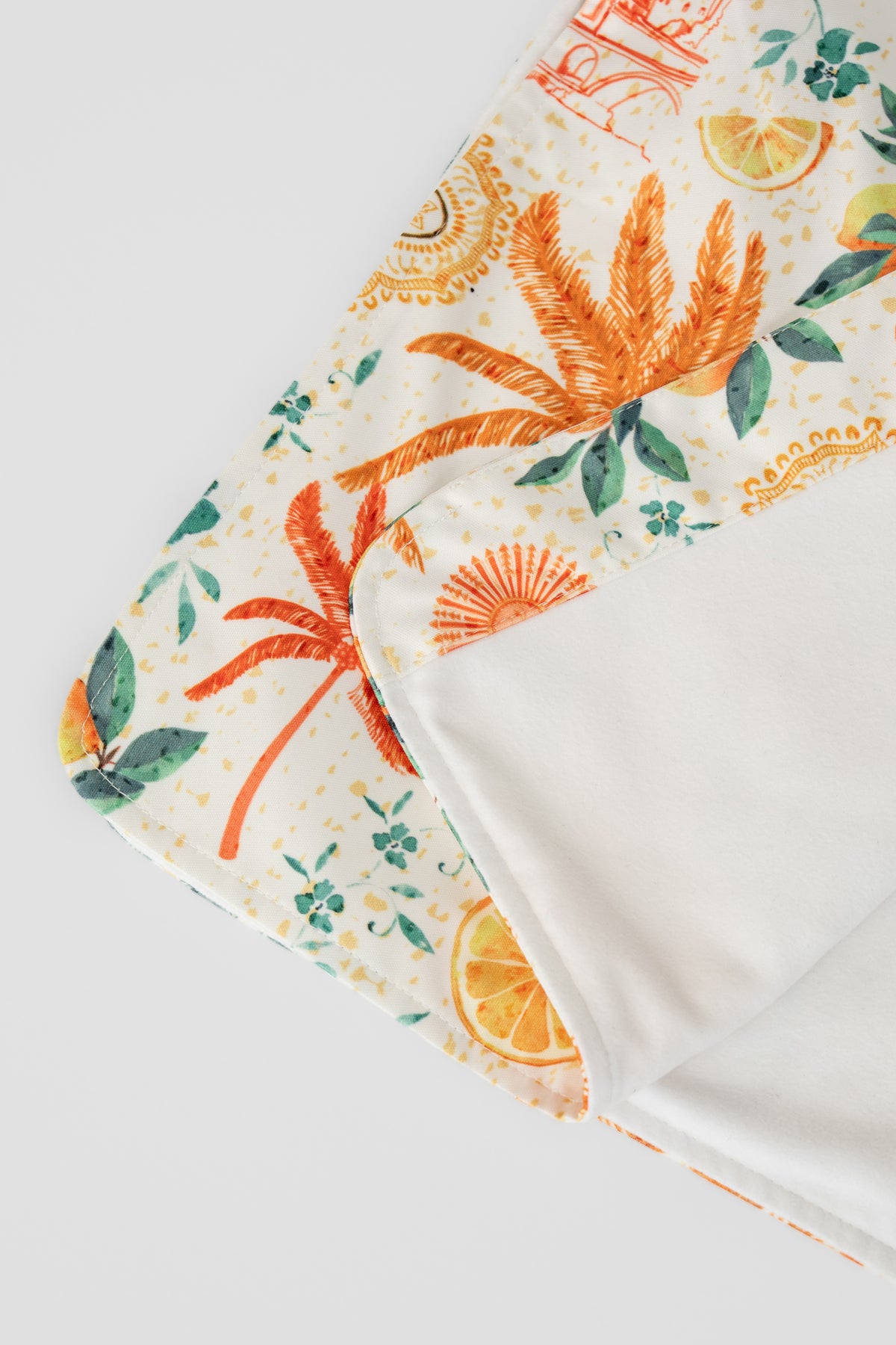 The Neren Signature After-Swim Dress in Valencia folded flat, showing the citrus and palm print