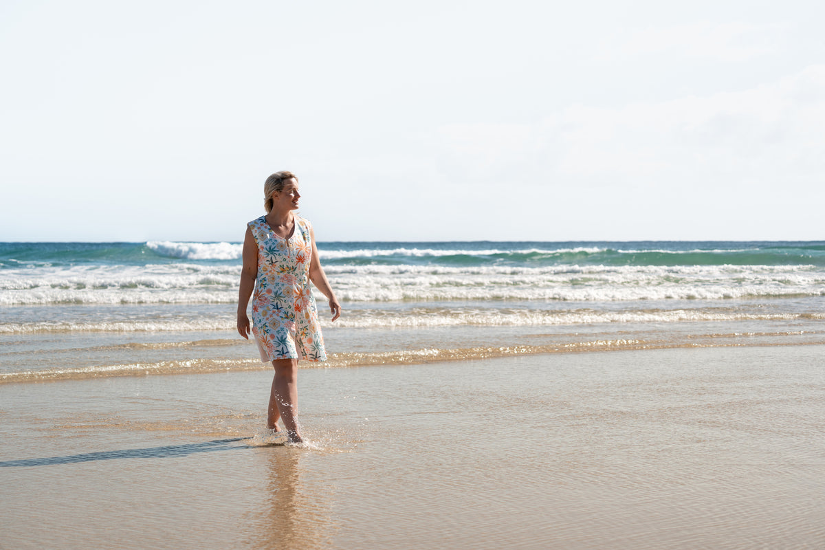 Woman in the Neren Signature After-Swim Dress in Valencia standing on the sand